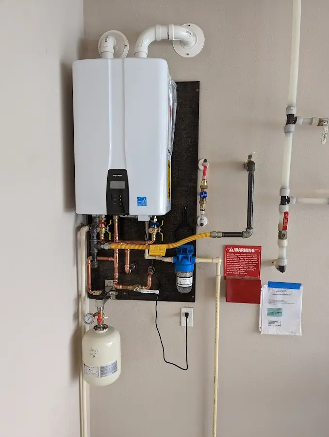 Professional plumber installing copper piping in a Durham home